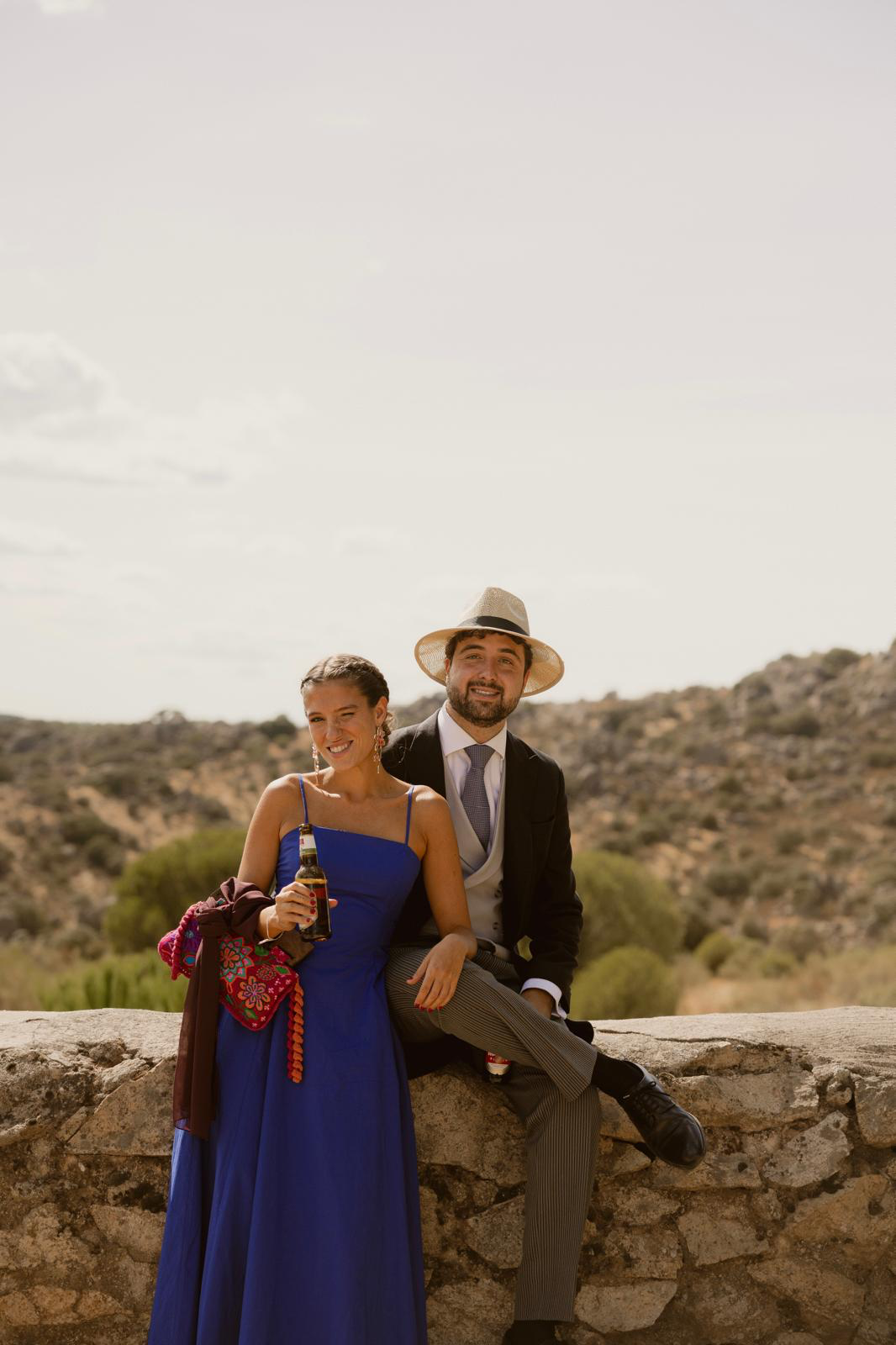 Lucía y Álvaro sentados en un muro de piedra en la sierra de Madrid